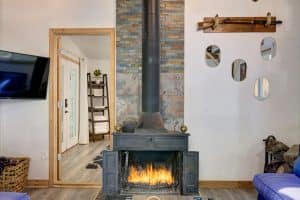 Photo of a woodstove with fire added to evoke the feeling being in this cozy Airbnb in the Catskills.